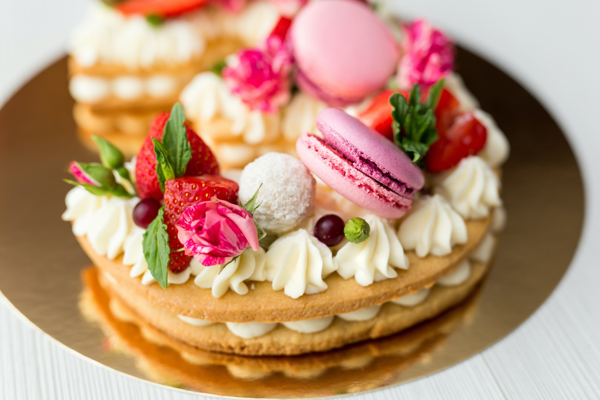 the-cake-with-cheese-cream-and-honey-cakes-is-decorated-with-flowers-berries-and-sweets-a-cake-in.jpg